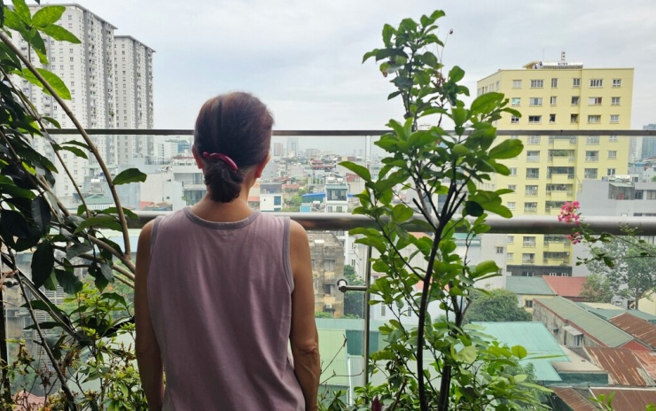 Bà Vân Anh, 71 tuổi, đứng trên ban công căn hộ của gia đình trên phố Láng Hạ. Ảnh: Nam Trung
