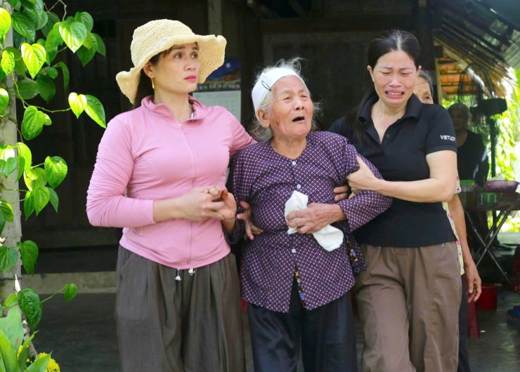 Bà Đường được người thân dìu ra trước ngõ đón linh cữu con trai. Ảnh: Q.Vinh