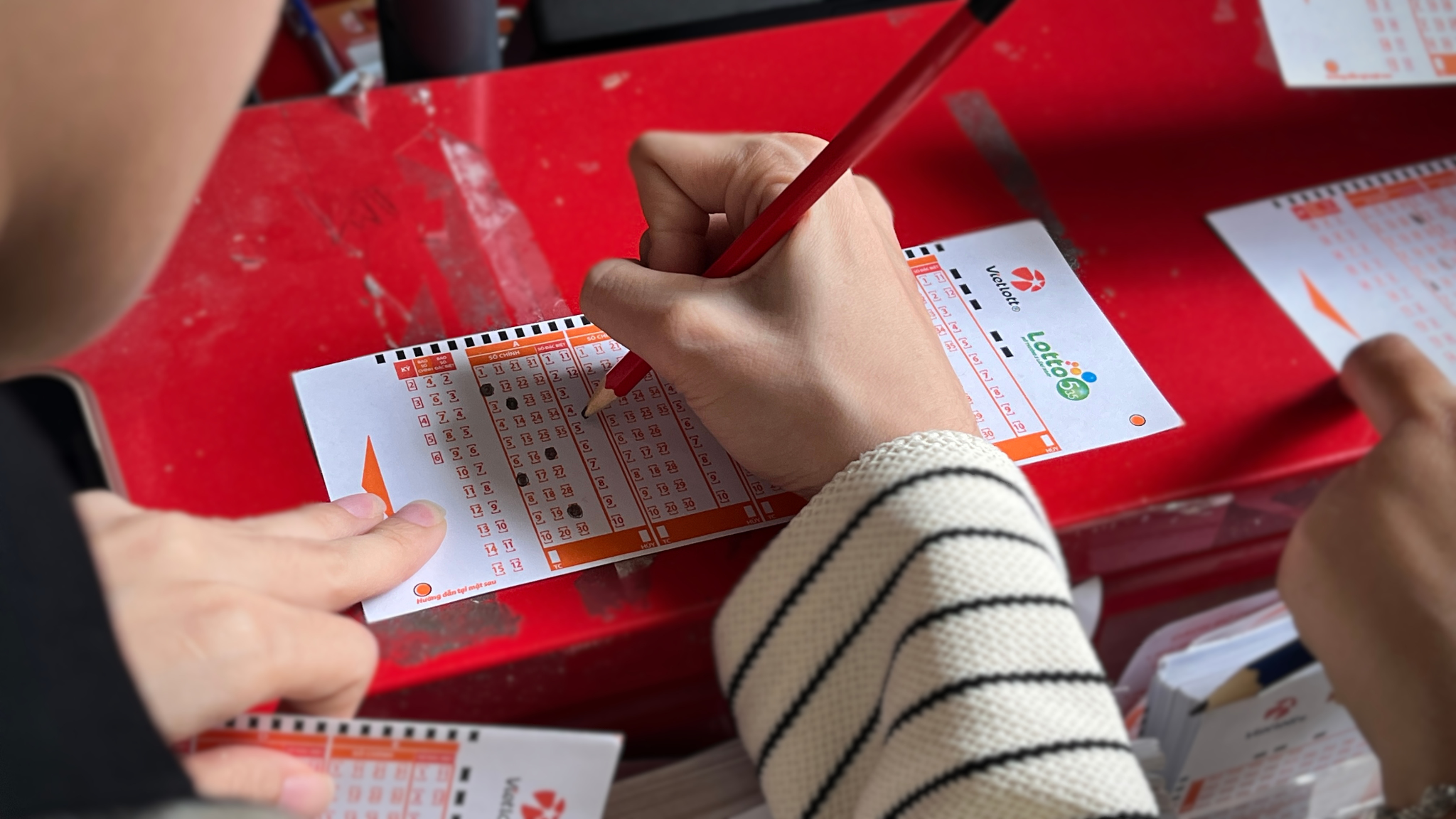 Khách hàng cẩn thận chọn từng con số trước khi tham gia dự thưởng Lotto 5/35. - Ảnh: DNCC