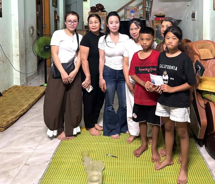 Bé Bích và em trai được chị Vui (thứ tư từ trái sang) và những người kêu gọi ủng hộ đến trao tiền cộng đồng mạng hỗ trợ, tối 3/8. Ảnh: Vui Lê