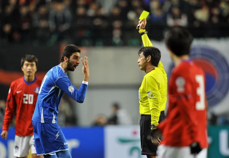 Trọng tài Yuichi Nishimura (phải) rút thẻ vàng với Fahed Al Ebrahim trong trận Hàn Quốc thắng Kuwait 2-0 ở vòng loại World Cup 2014 trên sân Seoul World Cup ngày 29/2/2012. Ảnh: AFP