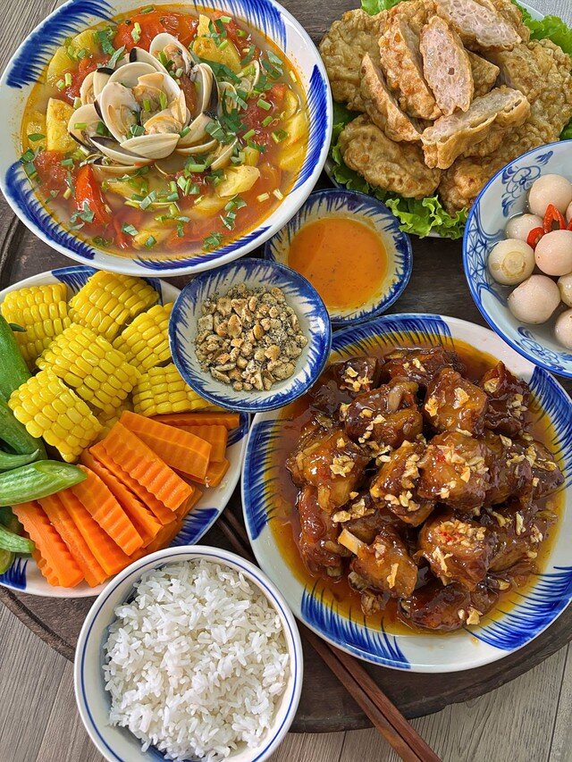 Sườn xào chua ngọt đậm đà ăn cùng canh ngao nấu dứa chua thanh, thêm đĩa rau củ luộc gồm lặc lày, ngô ngọt, cà rốt và vài miếng chả cốm rán thơm bùi. Một chút cà muối giòn giòn cũng đủ khiến nồi cơm vơi nhanh hơn.