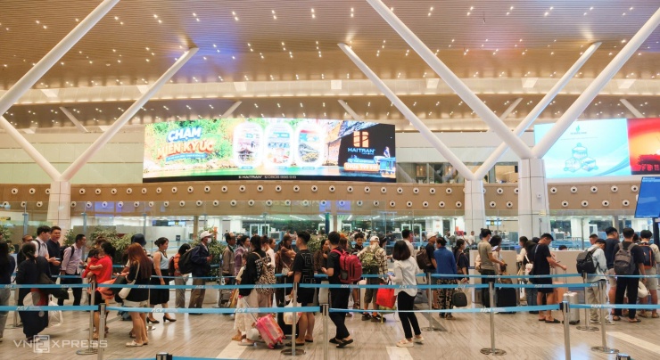 Hành khách xếp hàng chờ check in qua cổng an ninh ở nhà ga T3, sự cố UAV khiến nhiều chuyến bay đi bị ảnh hưởng, lùi giờ khởi hành nên lượng người tập trung làm thủ tục dồn về một thời điểm, đêm 11/8. Ảnh: Đình Văn