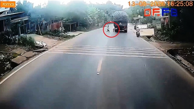 Thót tim cảnh cháu bé băng qua đường suýt bị xe đầu kéo tông (khoanh đỏ). Ảnh cắt từ clip
