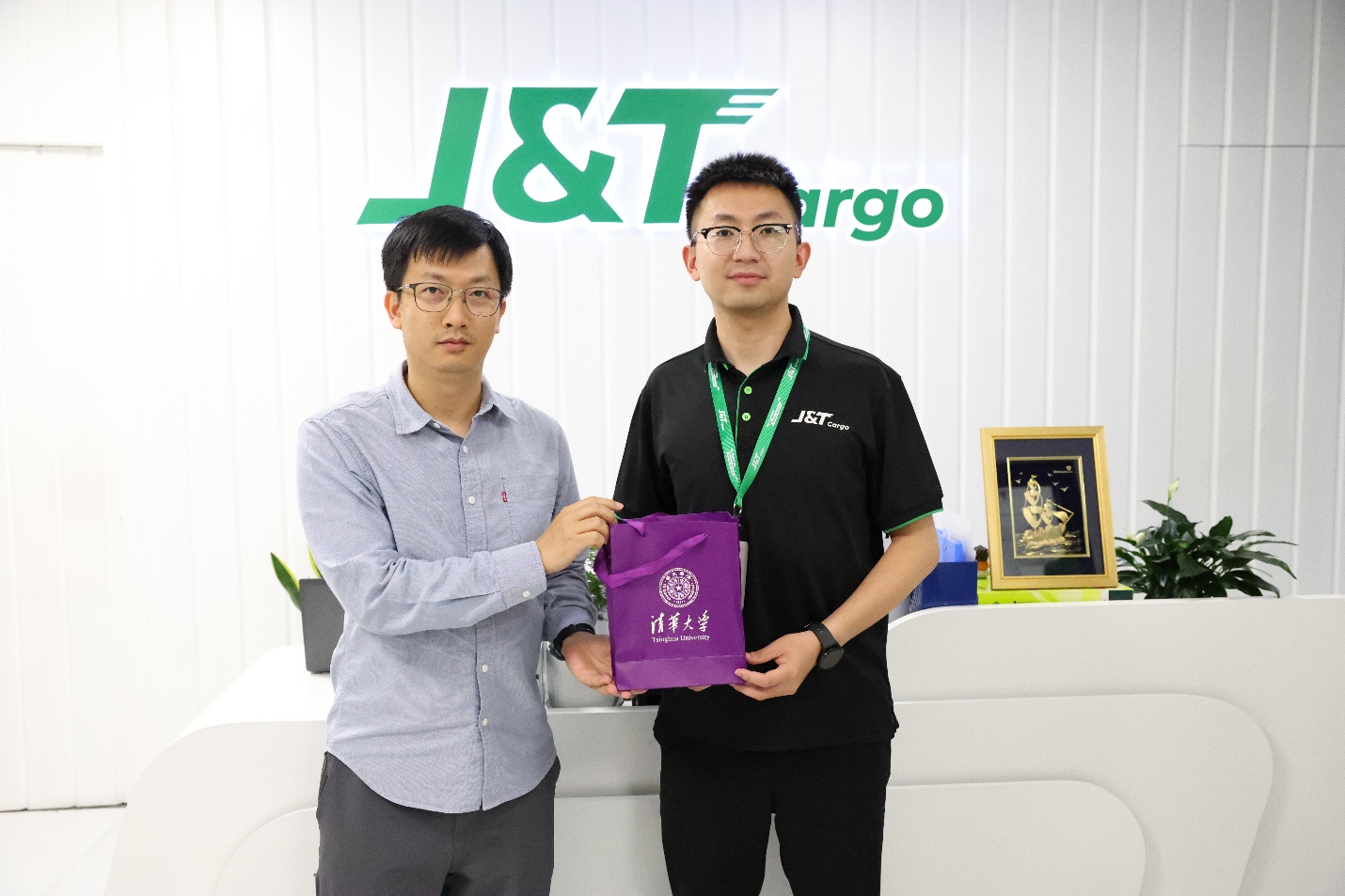 Tiến sĩ Quản Hạo (trái) đại diện ĐH Thanh Hoa trao quà lưu niệm cho ông Vương Hạo – Giám đốc Trung tâm Nhân sự J&T Cargo. Ảnh: J&T Cargo
