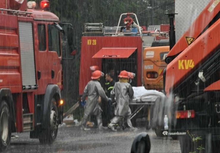 14h05, thi thể ba nạn nhân được đưa ra ngoài trong cơn mưa lớn. Cảnh sát vẫn đang phong tỏa, khám nghiệm hiện trường, điều tra nguyên nhân vụ cháy. Ảnh: Thanh Hà