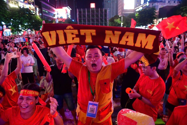 Nguyễn Lê Minh Thùy, 20 tuổi, hò reo ăn mừng sau bàn thắng của Xuân Son. Phút 63, Hoàng Đức căng ngang từ cánh trái, Xuân Son đệm hụt nhưng bóng bật đến Tiến Anh. Cú dứt điểm của hậu vệ Việt Nam chạm cầu thủ Malaysia rồi tìm đến Xuân Son, giúp tiền đạo này dễ dàng đưa bóng vào lưới trống, mở tỷ số. Việt Nam dẫn 3-0 sau hai lượt trận.