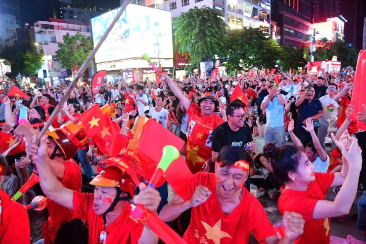 Nguyễn Lê Minh Thùy, 20 tuổi, hò reo ăn mừng sau bàn thắng của Xuân Son. Phút 63, Hoàng Đức căng ngang từ cánh trái, Xuân Son đệm hụt nhưng bóng bật đến Tiến Anh. Cú dứt điểm của hậu vệ Việt Nam chạm cầu thủ Malaysia rồi tìm đến Xuân Son, giúp tiền đạo này dễ dàng đưa bóng vào lưới trống, mở tỷ số. Việt Nam dẫn 3-0 sau hai lượt trận.