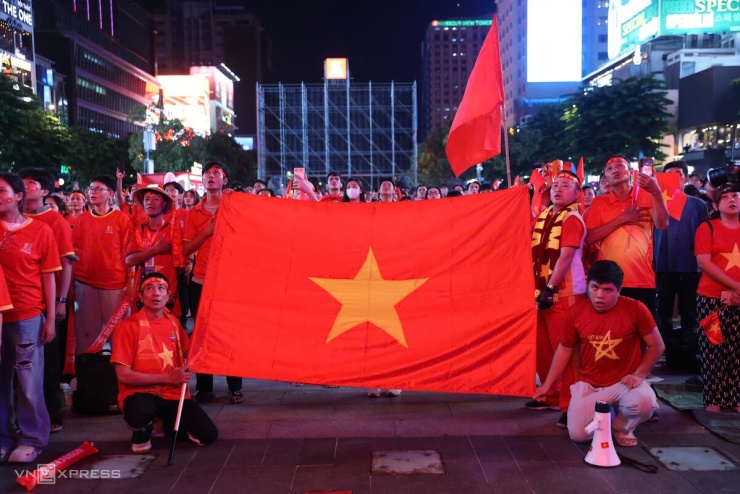 Người hâm mộ giương cao cờ Tổ quốc, hát Quốc ca trước giờ bóng lăn trên phố đi bộ Nguyễn Huệ. Chiến thắng giúp Việt Nam vượt qua Malaysia 4-0 sau hai lượt bán kết, giành quyền vào chung kết ASEAN Cup 2026 gặp Thái Lan.