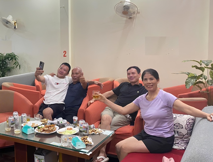 Ông Hùng (thứ hai từ trái sang) ăn mừng bàn thắng của Hai Long trong quán cafe, tối 22/8. Ảnh: Gia đình cung cấp