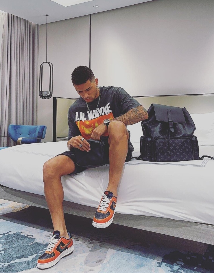Anh diện áo và sneakers đồng điệu, tăng vẻ thời trang với ba lô của Louis Vuitton.