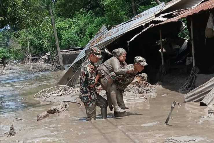 Binh sĩ Nepal giải cứu một người gặp nạn sau trận lũ quét ngày 26/8. Ảnh: SMH