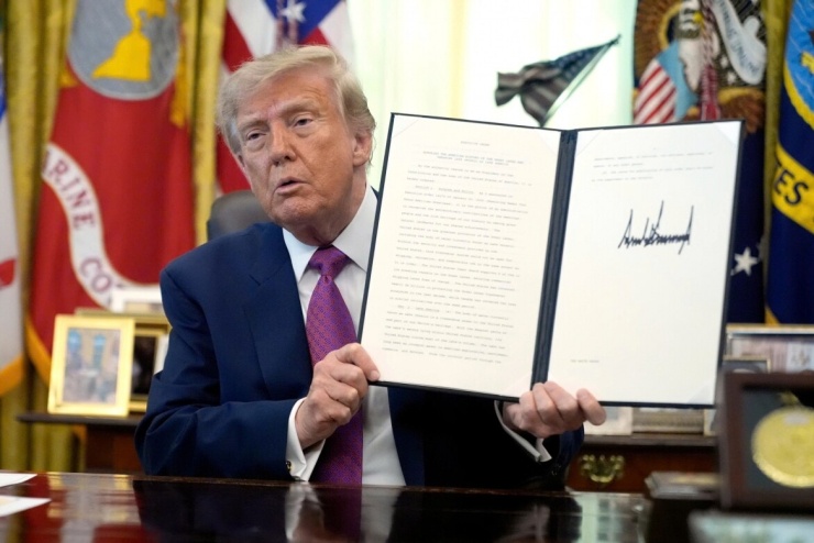 Tổng thống Mỹ Donald Trump giơ cao Sắc lệnh đổi tên Hồ Ontario thành “Hồ Mỹ” ngày 27/8/2026. Ảnh: AP
