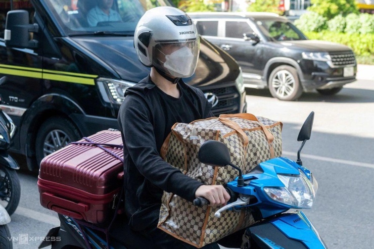Người dân chở hành lý bằng xe máy chạy trên đường Nguyễn Trãi. Ảnh:Thế Bằng