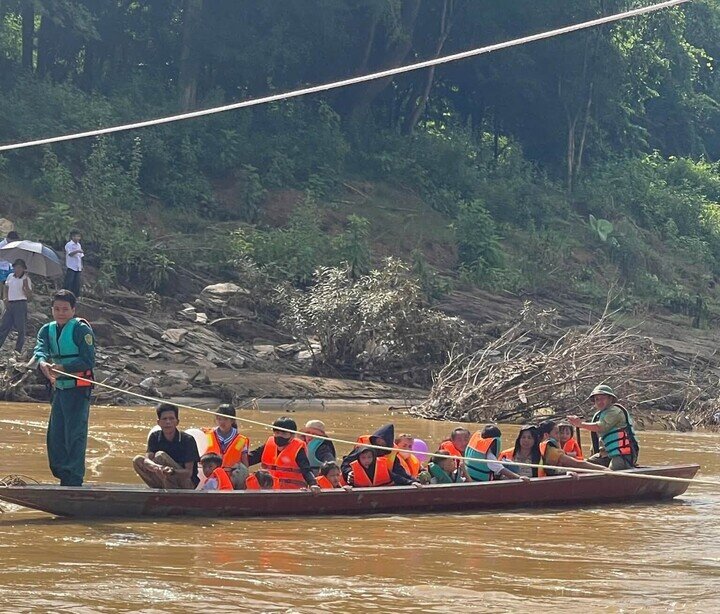 Lực lượng chức năng chèo thuyền đưa học sinh đi khai giảng. (Ảnh: Công an xã Yên Hòa)