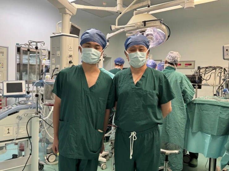 Huang Hongxin (trái) chụp cùng bác sĩ Long Long - người phẫu thuật tim cho anh 19 năm trước. Ảnh: Beijing Daily