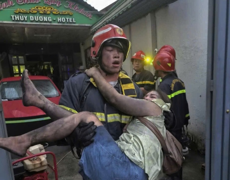  Lính cứu hỏa cứu người mắc kẹt ra ngoài. Ảnh: Phạm  Luận 