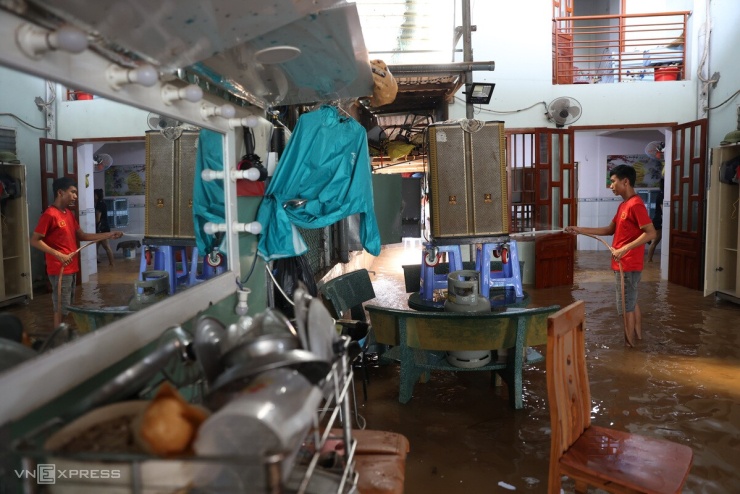Nước rút dần, anh Nguyễn Thế Thắng, 32 tuổi, dùng vòi xịt rửa đồ đạc trong nhà. Anh cho biết nước lên quá nhanh, không kịp kê tài sản nên nhiều xe máy và thiết bị điện tử bị hư hỏng.