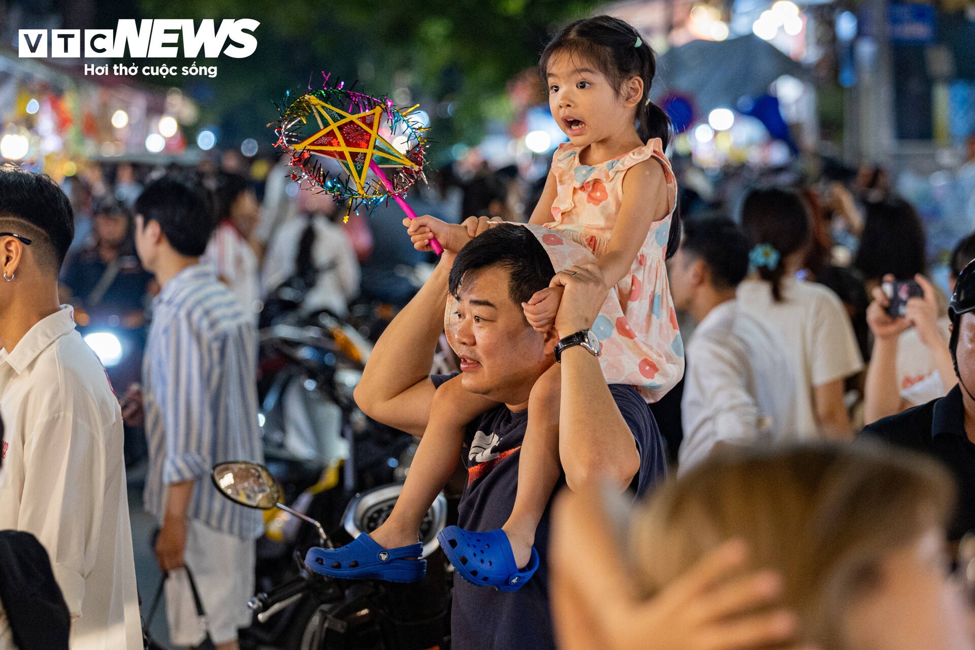 Để các con được ngắm trọn vẻ đẹp của các gian hàng, nhiều phụ huynh còn bế hoặc cõng con trên vai, còn các em bé tỏ rõ sự háo hức, đầy hứng thú.
