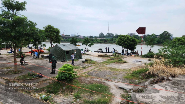 Lực lượng chức năng túc trực trên bờ sông chờ đợi kết quả tìm kiếm. Ảnh: Nguyễn Hoà