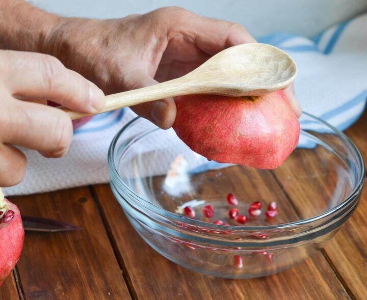 Dùng thìa gõ nhẹ làm hạt lựu tự rơi ra. (Ảnh: Kitchn)