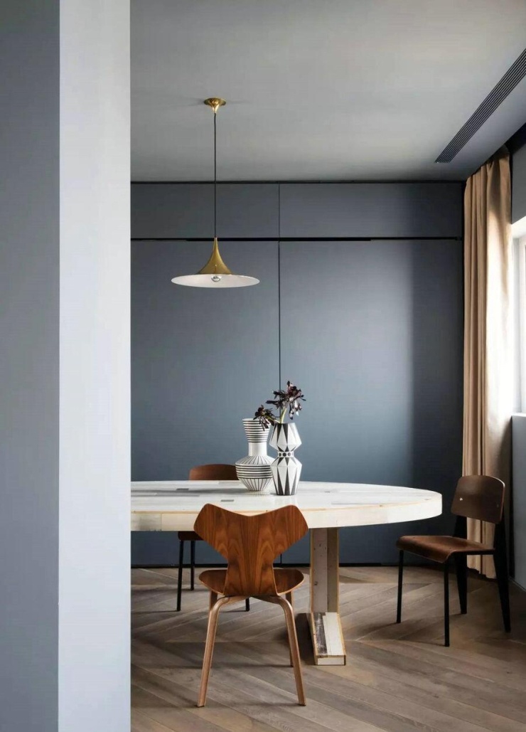 Bàn ăn ghép mảnh do nhà thiết kế Hà Lan Piet Hein Eek thực hiện. Tỉnh Bách Nhiên từng nhìn thấy phiên bản bàn dài khi đi Nhật Bản, sau đó chọn dạng oval để phù hợp hơn với diện tích và luồng di chuyển trong nhà. Trên bàn đặt nhiều món gốm gia chủ sưu tầm từ các chuyến đi, trong đó có đồ của thương hiệu Pháp Astier de Villatte.