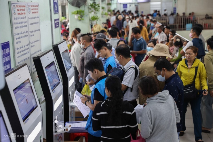 Khu vực lấy số tự động và quầy tiếp nhận luôn đông đúc. Khoảng một năm nay, nhờ triển khai đăng khám qua ứng dụng (app), nơi này bớt cảnh xếp hàng từ tờ mờ sáng. Hiện hơn 70% bệnh nhân đã đăng ký qua ứng dụng, chủ động đặt lịch từ trước, đến nơi chỉ cần in số thứ tự và đi thẳng đến phòng khám. Nhân viên Phòng Công tác xã hội cùng đội thanh niên tình nguyện - chủ yếu là sinh viên các trường đại học - có mặt từ sáng sớm để hỗ trợ người bệnh.
