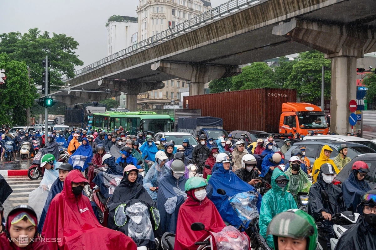 Nhiều người đi xe máy chôn chân giữa trời mưa. Ảnh: Thế Bằng