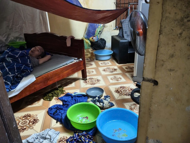 Chị Trang căng bạt, rải chậu, chảo ngăn nước chảy vào phòng trọ, sáng 17/9. Ảnh nhân vật cung cấp