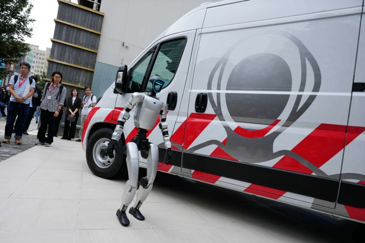 Robot hình người đứng cạnh xe cứu thương dành cho robot của GMO Internet tại Tokyo. Ảnh: AP