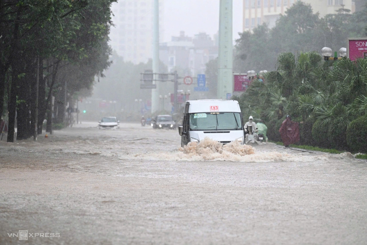 Ôtô di chuyển trong dòng nước ngập gần hết bánh xe. Ảnh: Phạm Chiểu