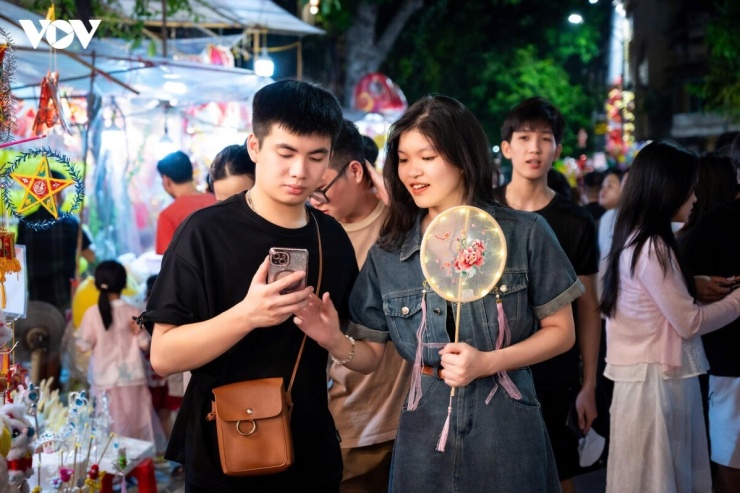 Giữa dòng người chen chân trên phố Hàng Mã, nhiều gia đình vẫn tìm một khoảng trống nhỏ để dừng lại, chụp ảnh và lưu giữ những khoảnh khắc đẹp trước Tết Trung thu.