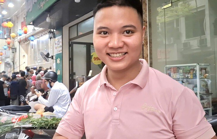 Anh Cao Xuân Tân sau gần một giờ xếp hàng, anh chỉ mua được 1 cặp bánh nướng - dẻo thập cẩm. Ảnh: QM. 