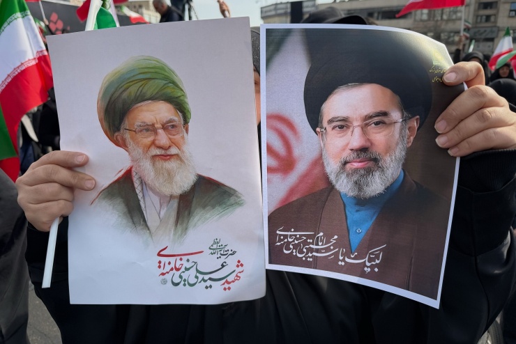 Người dân Iran cầm tranh vẽ cha con Lãnh tụ Tối cao trong cuộc tuần hành tại Tehran ngày 9/3. Ảnh: AFP