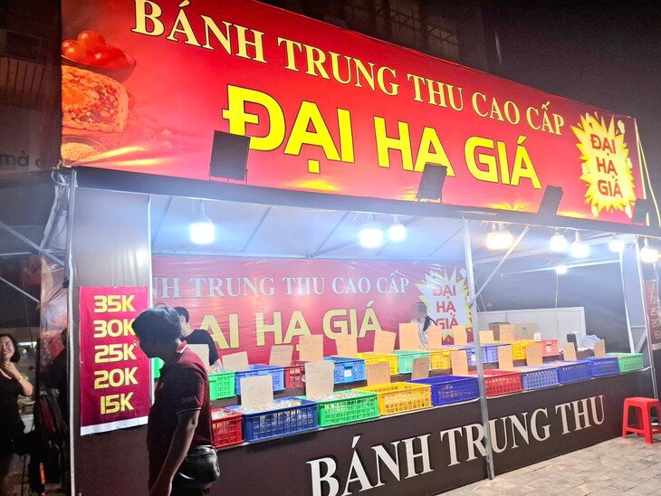 Tấm biển lớn với dòng chữ “Bánh Trung thu cao cấp - Đại hạ giá” được treo nổi bật nhằm thu hút người đi đường. Ảnh: Quỳnh Mai.