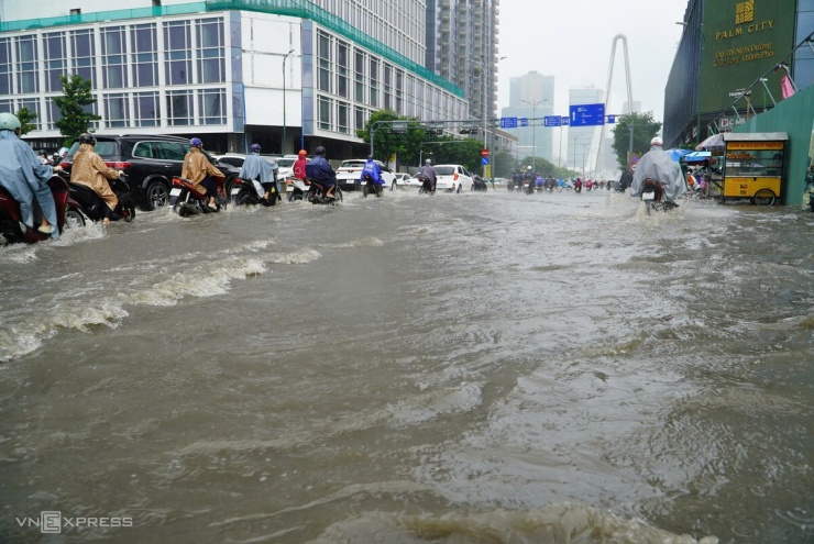 Đoạn đường trước cầu Ba Son ngập sâu khoảng 30 cm, kéo dài 50 m. Nhiều người phải né vùng ngập khiến dòng xe dồn ứ.