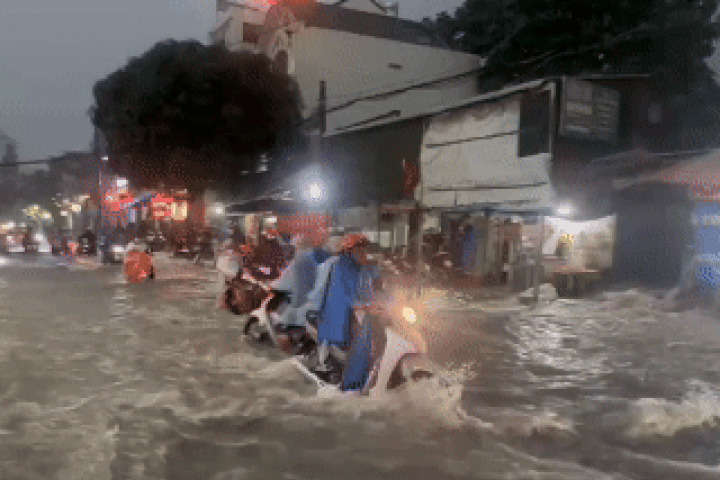 Nước chảy như thác cuốn ngã người đi xe máy ở TP HCM sau mưa lớn