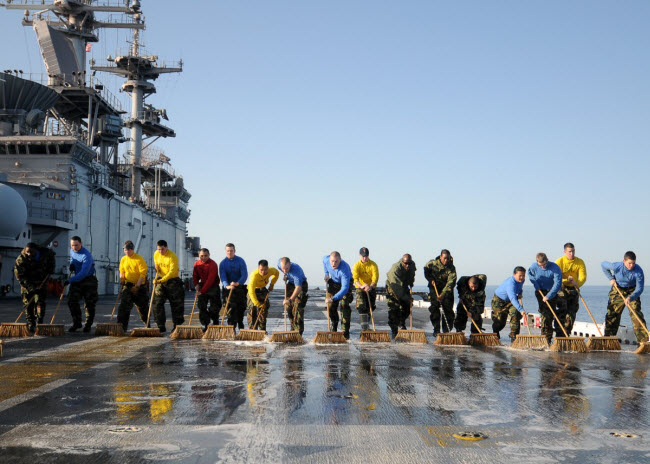 Các binh sĩ lau dọn trên boong tàu sân bay USS Essex.