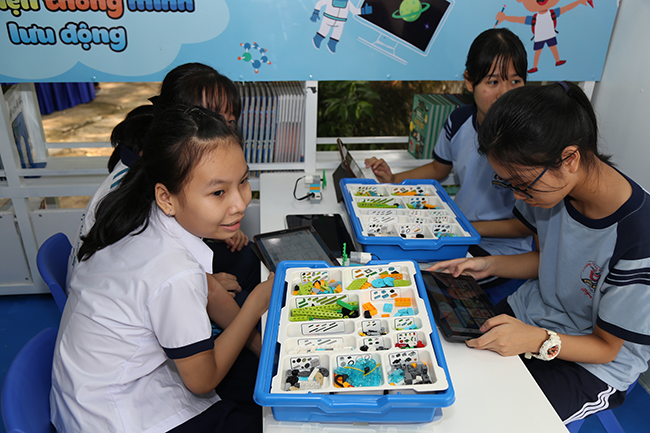 Các nữ sinh đang thích thú lắp ráp, lập trình mô hình lego ngay trên chiếc xe Thư viện Thông minh Lưu động. Thông qua môn học này, không chỉ tại Việt Nam mà trên thế giới đã diễn ra nhiều cuộc tranh tài robot thú vị.
