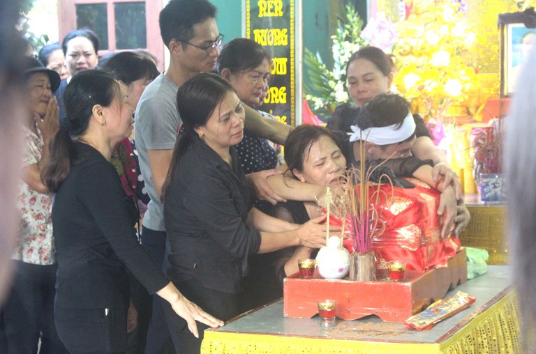 Bà Thúy ôm chặt di cốt con gái trong suốt buổi Lễ truy điệu. Ảnh: Đ.Tùy