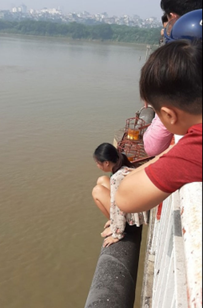 Hình ảnh người phụ nữ trèo qua lan can cầu định tự tử