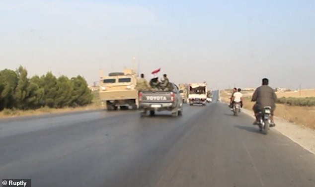 Xe&nbsp;chở binh sĩ Syria đi qua đoàn xe bọc thép Mỹ.