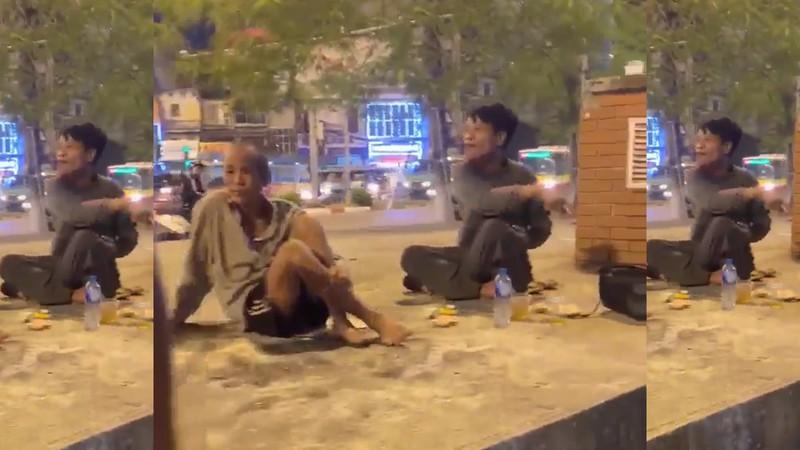 Hình ảnh 2 người đàn ông đang ngồi nhậu tại ngã tư Giải Phóng, trong đó 1 người (đầu trọc) đã đánh vị khách Tây.