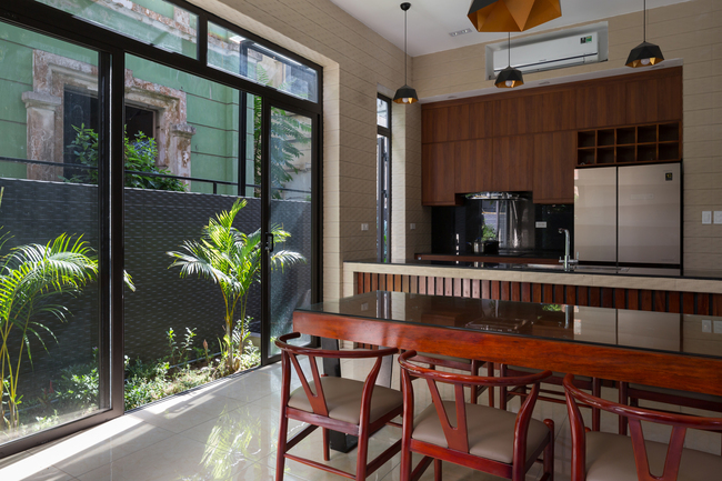 Khu vực bếp ăn đơn giản, gọn gàng, được thiết kế cùng lớp cửa kính lớn giao thoa với vùng đệm bên ngoài.