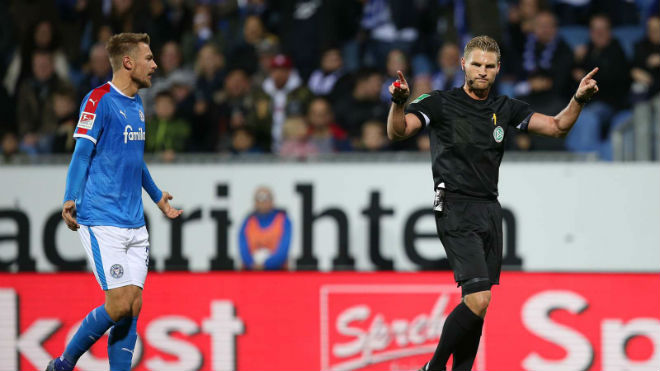 Cầu thủ dự bị đá bóng vào sân trước khi bóng đi hết đường biên ngang khiến Holstein Kiel bị trọng tài thổi phạt đền khi đấu Bochum