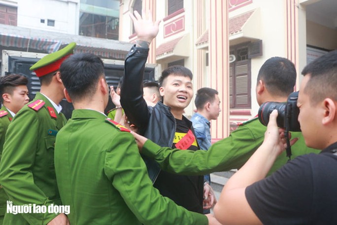 Khá "Bảnh" giơ tay vẫy vẫy khi bị dẫn giải từ xe đặc chủng tới tòa ngày 13-11 - Ảnh: Huy Thanh