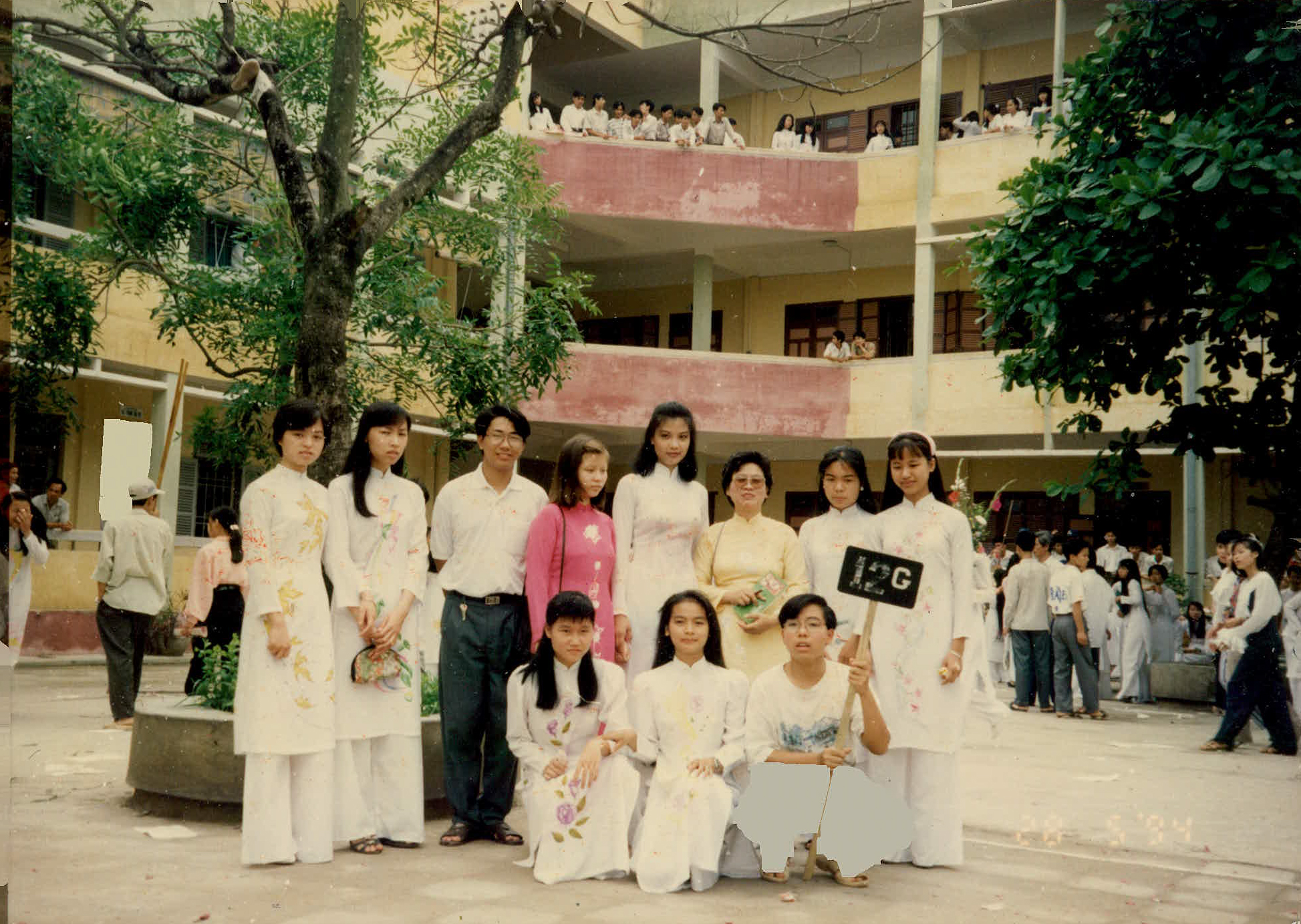 Vũ Cẩm Nhung&nbsp;mặc áo dài trắng, đứng giữa, nổi bật với chiều cao khủng ngay từ thời còn đi học
