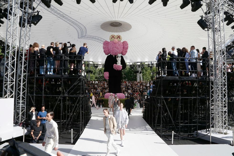DIOR HOMME XUÂN / HÈ 2019: Tại đường
băng Dior Homme của Kim Jones, một bức tượng hoa khổng lồ của nghệ
sĩ Kaws đã mô tả nhà thiết kế tên tuổi của nhà mốt là một con gấu
bông. Các mô tả được dựng dưới dạng hình họa hoạt hình cũng
được làm thành một món đồ chơi sang trọng, giống như Naomi
Campbell, Kate Moss và Kim Kardashian West trước khi chương
trình diễn ra.