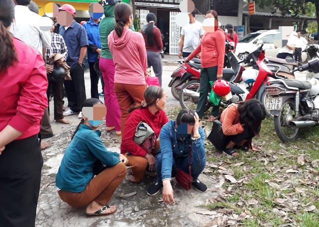 Người thân của các bị cáo gục đầu khóc hồi lâu trước cổng toà án sau khi nghe toà tuyên án phạt tù với con em của họ. Ảnh: Ngọc Vũ