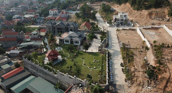 Ngay phía dưới tường bao, hàng rào là mái nhà của người dân trong khu vực, đất đá có thể trôi xuống bất cứ lúc nào, nhất là khi trời mưa gió.